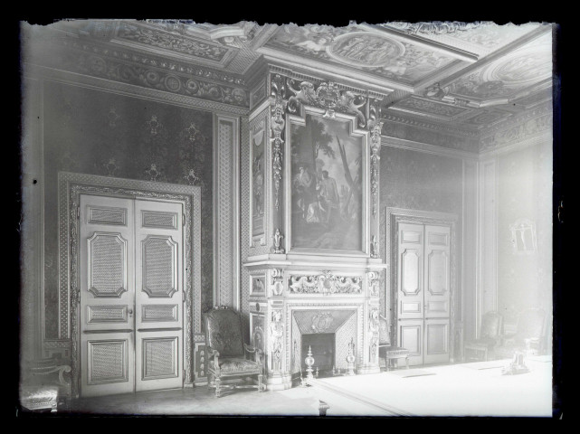 Salon d'une habitation avec cheminée à trumeau peint et plafond à caissons peints.