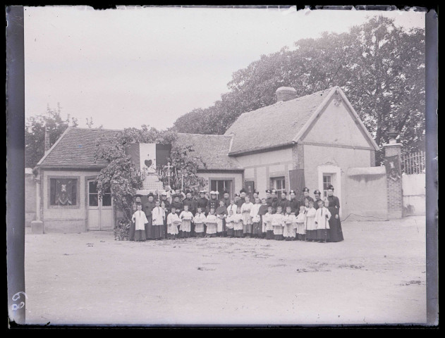 Religieuses du Sacré-Cœur et enfants de chœur devant une habitation.