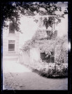 Femmes au balcon et au pied d'une habitation.