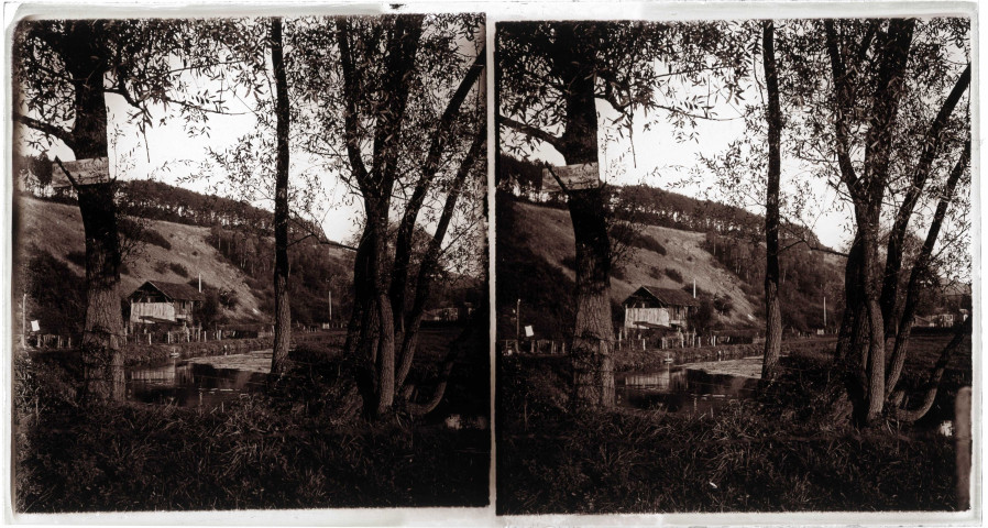 Grange au bord d'un étang dans la campagne normande.