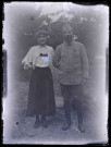 Femme et militaire français dans un jardin.
