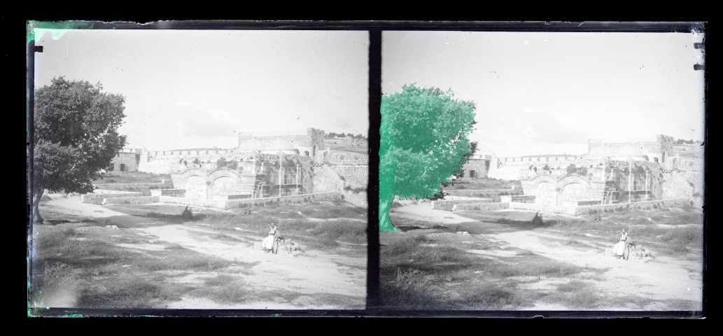 Bédouins dans la campagne devant des fortifications en ruine.