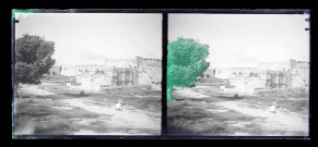 Bédouins dans la campagne devant des fortifications en ruine.