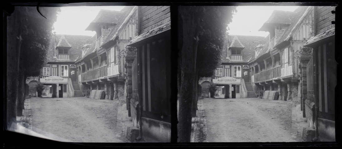 Cour intérieure d'un hôtel-restaurant à pans de bois.