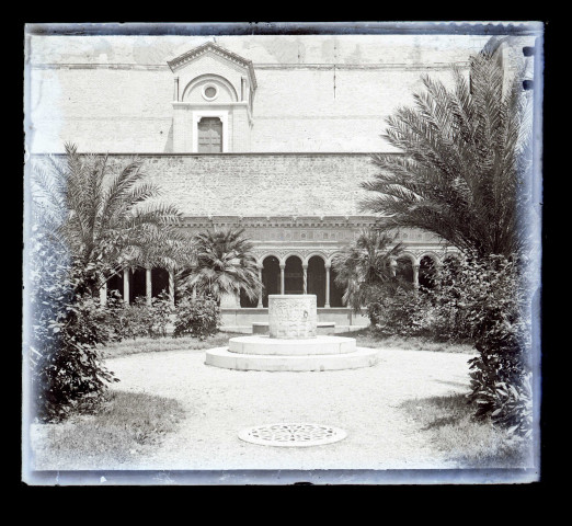 Cour intérieure avec puits, jardin et galerie à arcades.