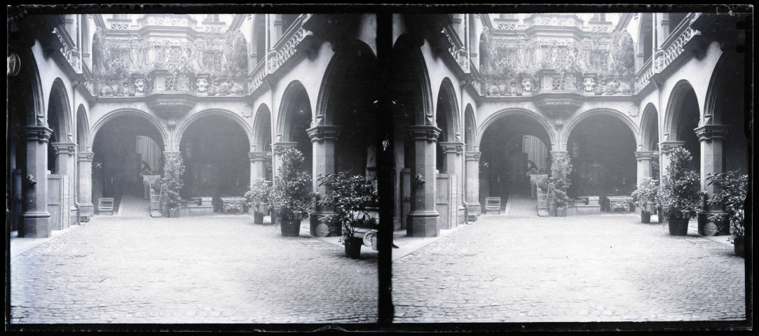 Cour intérieur d'habitation avec arcades et balcons ornementés.