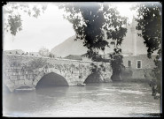 Pont en pierre traversant un fleuve et minaret.