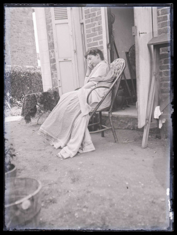 Femme au repos dans une chaise en bois.