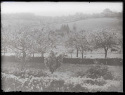 Vue sur un prieuré de campagne depuis un verger.