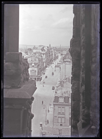 Vue d'une grande avenue commerçante à travers les galbes de la cathédrale de Reims (Marne).