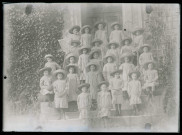 Groupe d'enfants en uniforme sur le perron d'une habitation.