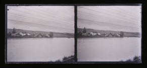 Village bordé par un fleuve vu de l'autre rive.