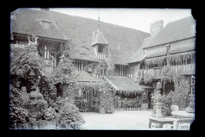 Cour intérieure d'un manoir à pans de bois, probablement un hôtel.