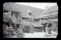 Cour intérieure d'un manoir à pans de bois, probablement un hôtel.