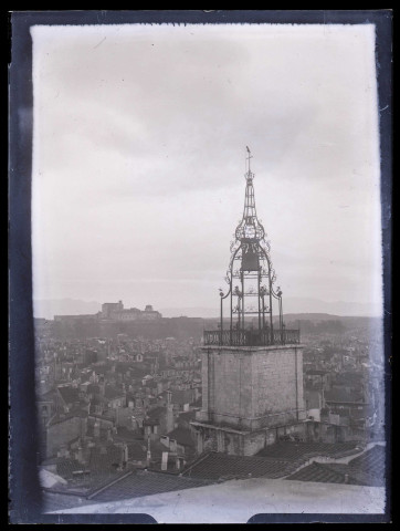 Vue générale d'une ville avec une église au clocher en ferronnerie.