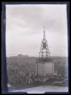 Vue générale d'une ville avec une église au clocher en ferronnerie.