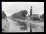 Femmes au lavoir sur la berge d'une rivière.