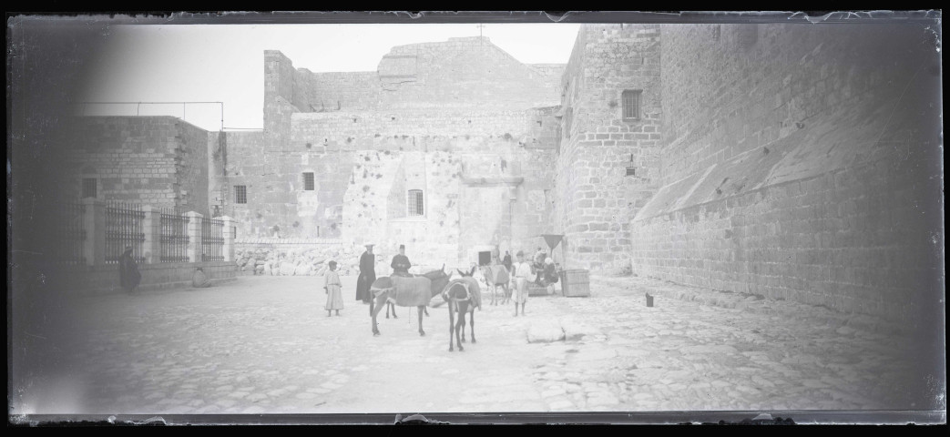 Prélats, âniers et leurs montures au pied de fortifications.