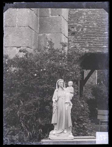 Église de Saint-Jean-du-Thenney (Eure), statue de Vierge à l'enfant posée dans un jardin.