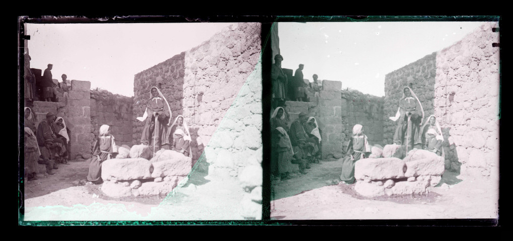 Femmes, hommes et enfants autour d'un puits dans les fortifications d'une ville algérienne.