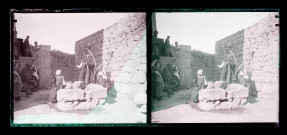 Femmes, hommes et enfants autour d'un puits dans les fortifications d'une ville algérienne.