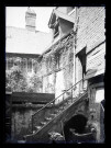 Arrière-cour avec puits et escalier de pierre d'une maison à pans de bois de Lisieux (Calvados).