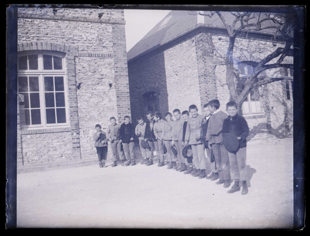 Groupe de jeunes garçons dans la cour d'un bâtiment.