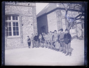 Groupe de jeunes garçons dans la cour d'un bâtiment.