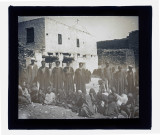 Groupe de jeunes enfants assis et adulte devant un édifice religieux.