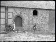 Jeunes enfants et leur âne dans une cour de ferme normande.