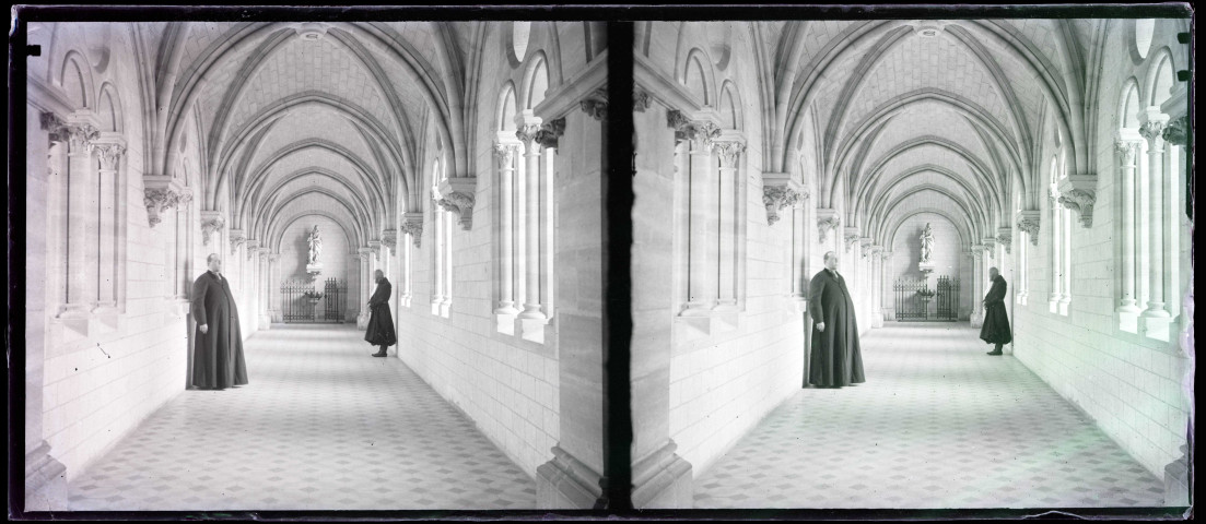Le chanoine Le Fournier habit sacerdotal et moine dans la galerie d'un cloître.