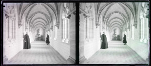 Le chanoine Le Fournier habit sacerdotal et moine dans la galerie d'un cloître.