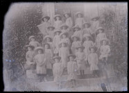 Groupe d'enfants en uniforme sur le perron d'une habitation.