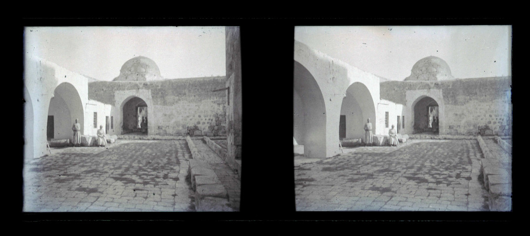 Cour pavée et mausolée.