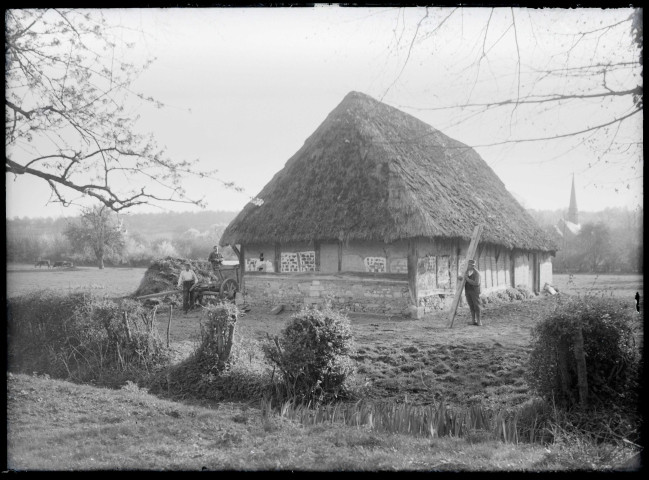 Paysans dans les champs devant une grange dans les environs de Ménesqueville (Eure).