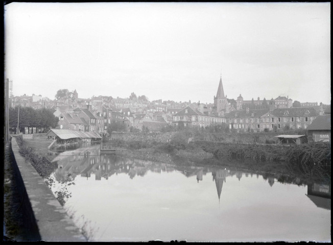 Vue sur une ville et ses lavoirs au bord de la rivière.