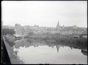 Vue sur une ville et ses lavoirs au bord de la rivière.