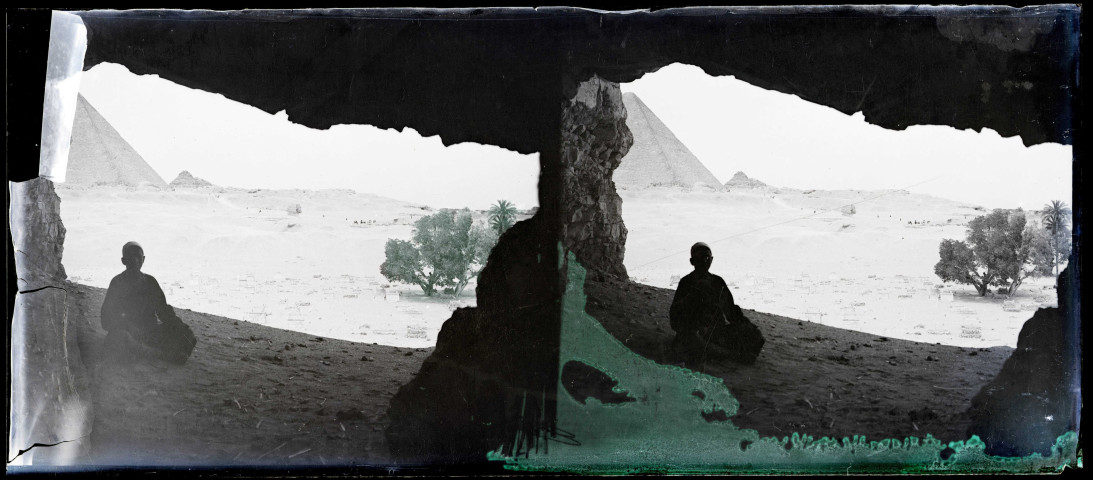Enfant assis à l'ombre près des pyramides de Khéops (Égypte).