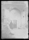 Prêtre arménien devant la porte d'un édifice en pierre à Kozan (Sis) (Turquie).