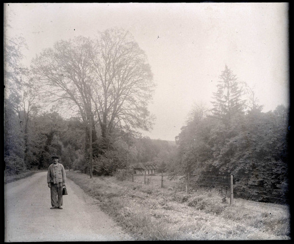 Vieil homme sur le chemin longeant les dépendances (box à chevaux) du château de Rosay-sur-Lieure (Eure).