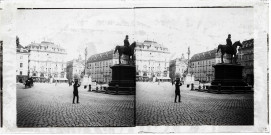 Grande place animée avec statue équestre, calèches, rail de tramway et bâtiment monumental.