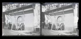 Bédouins à la fontaine et marins français dans les ruelles d'un souk en Algérie.