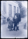 Militaire français et enfants sur un chemin devant un bâtiment.