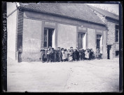 Groupe d'enfants devant le mur d'une habitation lors des trois derniers jours de février 1899.