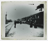 Groupe d'ecclésiastiques et de personnes handicapées en pèlerinage pour Lourdes (Hautes-Pyrénées) à la gare. On reconnaît une membre ou amie de la famille Bretocq en blanc à la droite d'un prêtre.