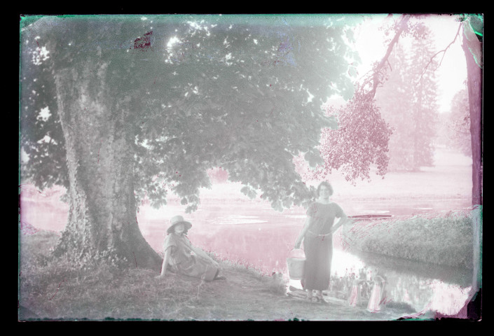Jeunes femmes sous un marronnier au bord de la rivière traversant le parc du château de Rosay-sur-Lieure (Eure).