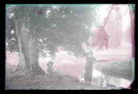 Jeunes femmes sous un marronnier au bord de la rivière traversant le parc du château de Rosay-sur-Lieure (Eure).