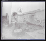Vieille femme appuyée sur la margelle d'un puits dans un village de la campagne de Charente-Maritime.
